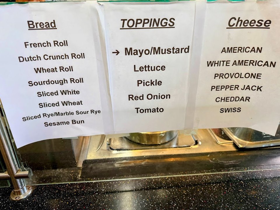 Menu board listing roast beef, turkey, and pastrami.
